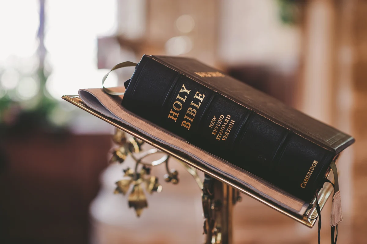 A Holy Bible resting on a church book stand.