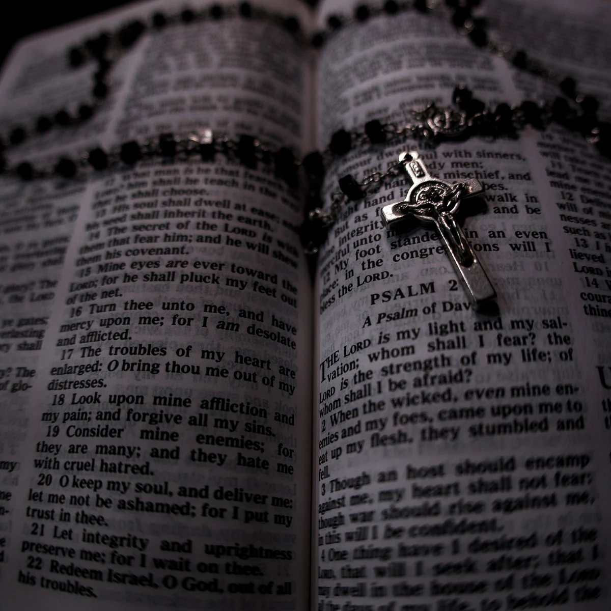 An open Bible at the Psalms with a crucifix resting on the pages.